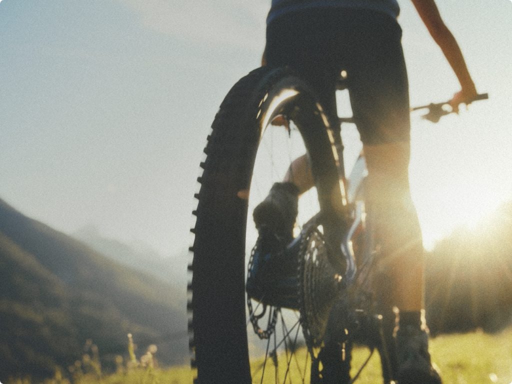 person riding a bike along a mountain path during sunrise