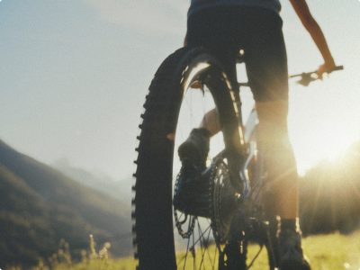 person riding a bike along a mountain path during sunrise