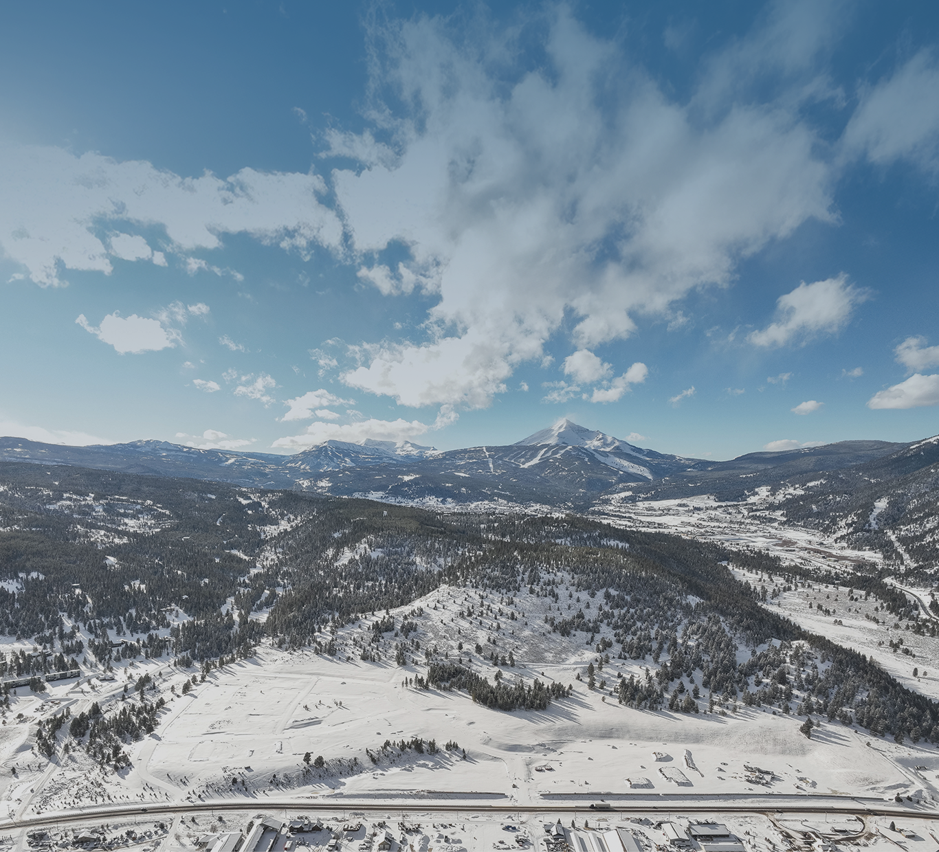 Aerial view of Big Sky Quarry community with mountain landscape and open sky, showcasing natural surroundings and residential area